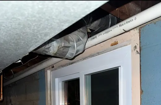 Old drafty basement window replaced with a new energy-efficient vinyl slider window