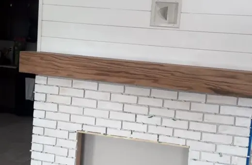Brick fireplace surround installed and ready for grouting as part of an ongoing renovation