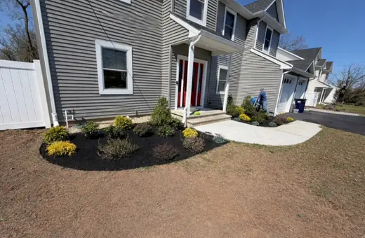 Front yard landscape makeover with old plantings removed and a new design featuring stone accents