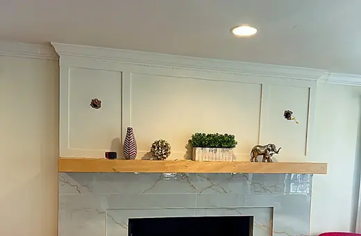 Custom fireplace surround with large-format porcelain tile and rich veining for a seamless, luxurious look